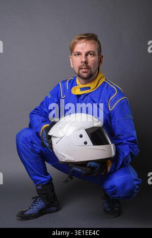 Portrait d'homme barbu blond motocycliste avec barbiche dans la pleine vitesse contre l'arrière-plan gris Banque D'Images