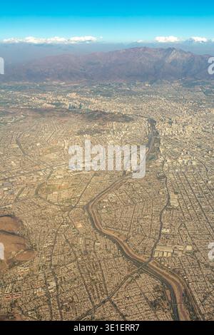 Une vue aérienne capture le paysage urbain tentaculaire de Santiago, au Chili, niché dans les montagnes des Andes en toile de fond, mettant en valeur le paysage urbain de la ville Banque D'Images