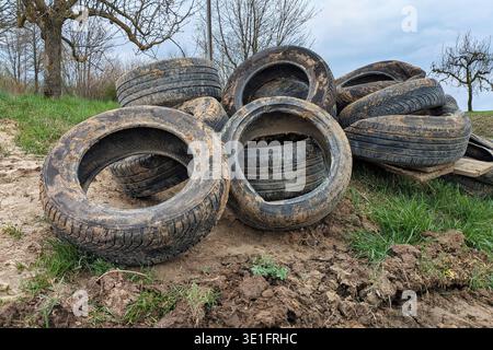 Pile de vieux pneus jetés dans le Danube. Élimination illégale des déchets et pollution de l'environnement Banque D'Images