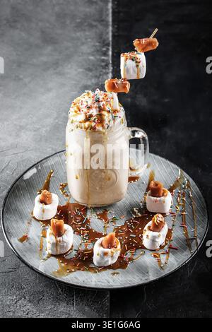 Gâteau crémeux avec guimauves rôties. Milk-shake à la guimauve sucrée décoré de garnitures et de saupoudres Banque D'Images