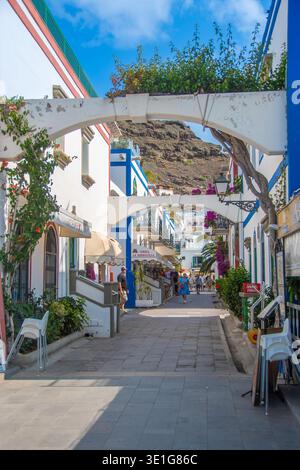 Puerto de Mogan, Espagne 17 mai 2025, pittoresque rue piétonne à Puerto de Mogan sur Gran Canaria avec des maisons blanches et bleues Banque D'Images