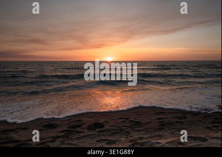 Beau coucher de soleil sur l'océan avec des empreintes de pas dans le premier groupe Banque D'Images