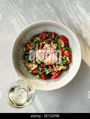 Salade de thon et de tomates fraîches. Déjeuner d'été décontracté avec légumes vibrants et présentation simple Banque D'Images