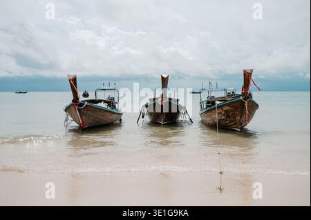 Trois bateaux à longue queue ancrés à Railay West Beach à Krabi Thaïlande Banque D'Images