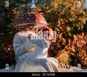 Maman et bébé nouveau-né comme champignons rouges dans la forêt d'automne Banque D'Images
