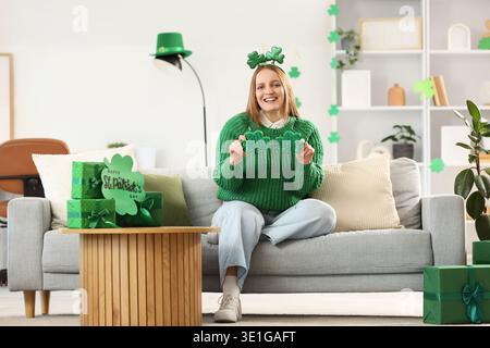 Rousse jeune femme avec des lunettes en forme de trèfle à la maison le jour de Patrick Banque D'Images