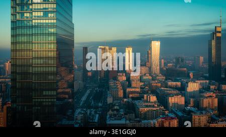Varsovie, Pologne - 06 février 2023 : vue aérienne d'un paysage urbain moderne avec des gratte-ciel imposants qui brillent au soleil, projetant de longues ombres à travers t Banque D'Images