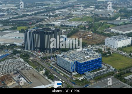 Vue aérienne du grand bâtiment bleu du centre de données, d'autres installations industrielles et d'une nouvelle construction, Jakarta, Indonésie. Banque D'Images