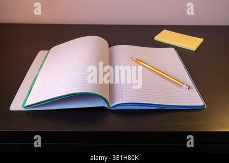 Ouvrez le carnet avec un crayon sur une table en bois sombre Banque D'Images