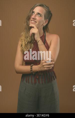 Studio shot of young Beautiful woman contre fond brun Banque D'Images