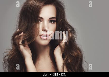 Portrait de belle jeune femme avec de longs cheveux ondulés Banque D'Images