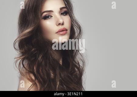Portrait de belle jeune femme avec de longs cheveux ondulés Banque D'Images