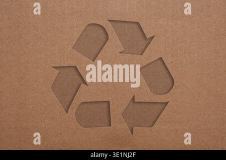 Icône de symbole de recyclage en relief sur fond de texture de carton ondulé brun Banque D'Images