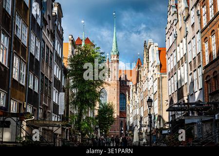 Vue le long de la rue Mariacka en direction de la flèche de la basilique Sainte-Marie avec ses façades hanséatiques historiques, ses cafés en plein air, Gdańsk, Voïvodie de Poméranie, Pologne Banque D'Images