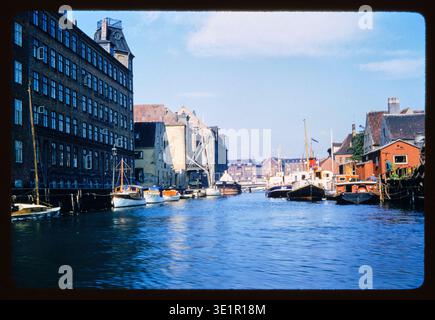Vue sur un canal d'eau typique, plein de bateaux de plaisance commerciaux amarrés. À Copenhague, Danemark. Cette diapositive, image Kodachrome, a été prise par un touriste américain lors d'un voyage en Europe en 1959. La couleur de la photographie est vibrante, presque teintée à la main, peinte. Banque D'Images