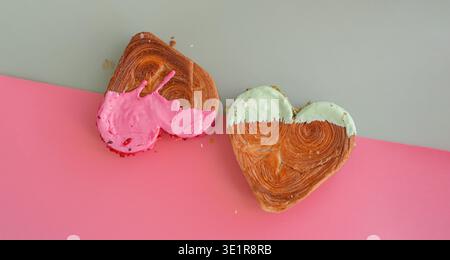 Idée isométrique créative fête de la Saint-Valentin fête des croissants en forme de coeur sur fond de deux couleurs avec espace de copie. Pâte feuilletée nouvelle boulangerie à dessert sucré à la mode. Expérience sur pâte crémeuse Banque D'Images