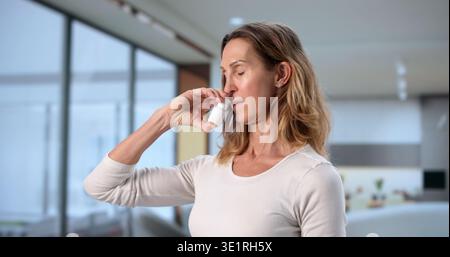 Femme tenant le spray nasal pour le soulagement des allergies et les symptômes de la grippe Banque D'Images