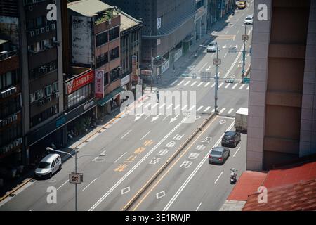 Taipei, Taïwan - 5 juillet 2023 : vue à angle élevé de l'intersection de Dadaocheng avec des marquages routiers, des voitures et un shophouse traditionnel à la lumière du soleil. Banque D'Images