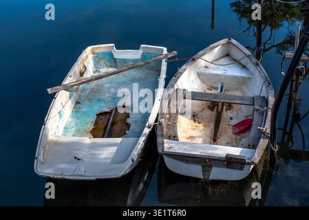 Gros plan de deux petits bateaux de pêche abandonnés et cassés immergés dans l'eau de la lagune de Venise Banque D'Images