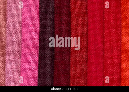 Tissus de velours épais disposés dans un ordre chromatique allant du rose poussiéreux au rouge vif et à l'orange. Texture en gros plan, même lumière de studio. Interi Banque D'Images
