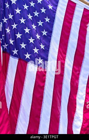 Texture détaillée du drapeau des États-Unis, mettant en valeur des étoiles brodées sur un fond bleu et alternant des rayures rouges et blanches Banque D'Images