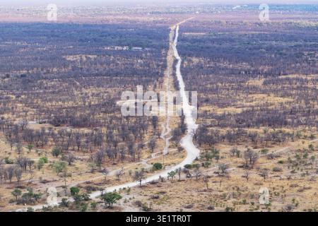 Une vue aérienne d'une route sablonneuse droite qui pourrait être difficile pendant la saison sèche près de Maun, Botswana Banque D'Images