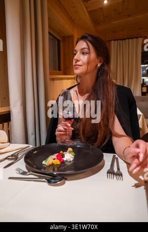Dîner élégant dans le restaurant alpin de l'hôtel avec vin rouge et plat raffiné Banque D'Images