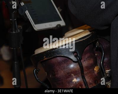 Gros plan d'un tambour bongo utilisé dans un décor musical live, mettant en évidence l'instrument à percussion et son corps en bois Banque D'Images
