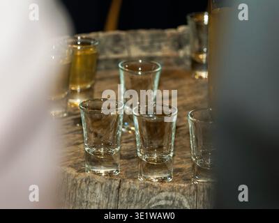 Verres à liqueur vides sur une table en bois dans un cadre de bar, prêt pour le service d'alcool lors d'une fête ou d'un événement de la vie nocturne. Banque D'Images