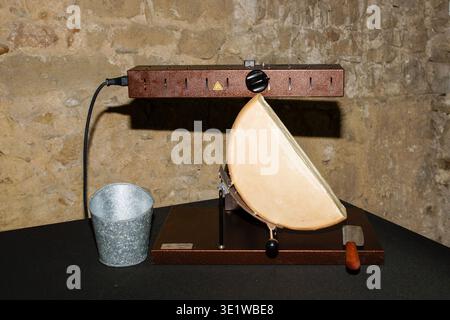 Fromage à raclette fondant sous un élément chauffant. Banque D'Images