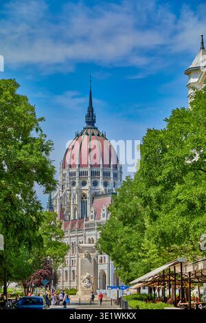Rue piétonne dans la ville de Budapest avec café et le Mémorial du Martyr au bout de la rue avec le dôme du bâtiment du Parlement hongrois Banque D'Images