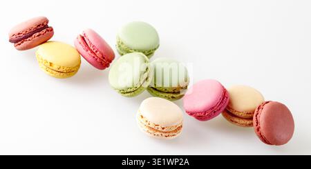 Biscuits colorés sucrés français macarons macarons volant sur fond neutre clair. Bannière de pâtisserie avec espace de copie Banque D'Images