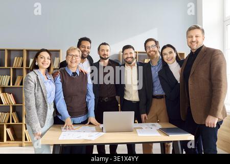 Portrait d'équipe d'affaires diversifié heureux debout ensemble dans un bureau moderne lumineux Banque D'Images