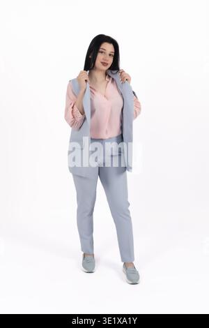 Femme élégante en costume d'affaires debout et regardant loin Banque D'Images
