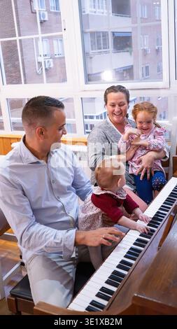 Heureux lien de famille en jouant du piano et en chantant des chansons ensemble Banque D'Images