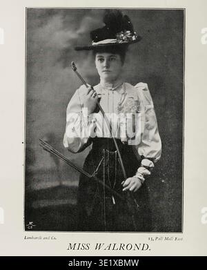 Miss Walrond, une sportive dans un portrait de studio, tient un arc et trois flèches, vêtue d'un chapeau et d'un chemisier à la mode, représentant l'élégance vintage et le tir à l'arc historique. La bibliothèque de la sportive éditée par Frances E. Slaughter Publisher Westminster : A. Constable 1898 Banque D'Images