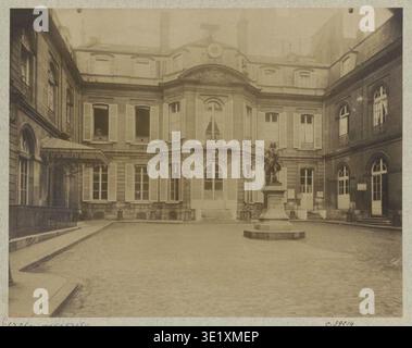 Eugène Atget (1857-1927) est un photographe français spécialisé dans l'architecture parisienne. Le tirage photographique historique APMDP045927 documente la façade de la cour de la Mairie et du Hôtel du fermier général d'Augny, dont une statue de Voltaire. Banque D'Images