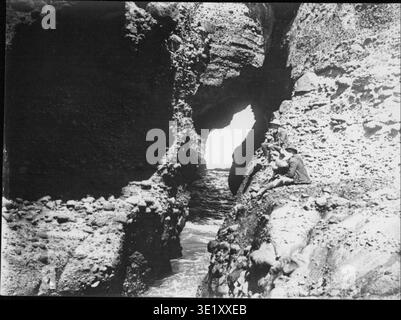 La photographie de Henry Winkelmann de 1892 à 1928 capture le trou de soufflage à Piha, une caractéristique côtière populaire à Auckland, en Nouvelle-Zélande. L'image met en évidence la beauté naturelle et les caractéristiques géologiques de la région. Banque D'Images