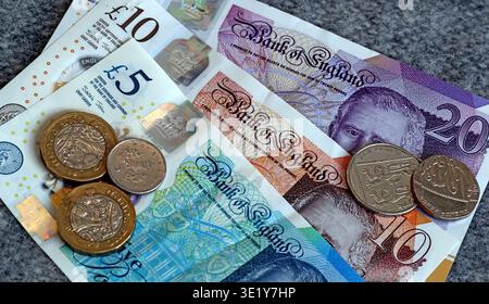Billets de banque du roi Charles III de la Banque d'Angleterre avec des pièces britanniques montrés en gros plan comme un concept de monnaie britannique et de finances personnelles Banque D'Images