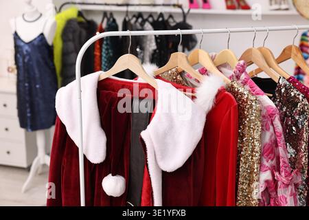 Différents vêtements de fête accrochés sur rack dans le dressing, gros plan Banque D'Images