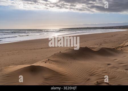 Vue panoramique sur les dunes de Punta Pisciotto, Sampieri. L'image met en évidence les ondulations de sable doré au premier plan, en pente vers le large bea Banque D'Images