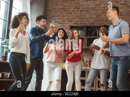 Groupe d'amis excités faisant la fête à la maison Banque D'Images