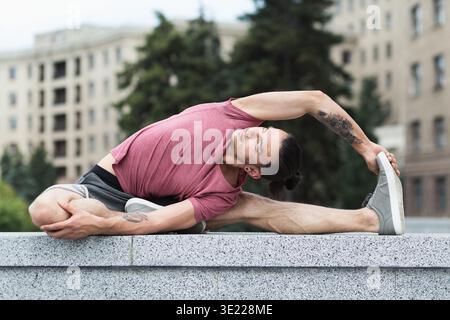 Homme faisant des exercices d'étirement de yoga dans la ville Banque D'Images