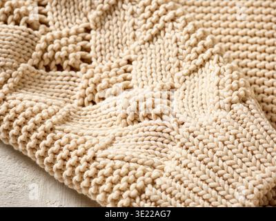 Gros plan de tricot beige détaillé avec motif texturé sur fond clair. Allemagne Banque D'Images