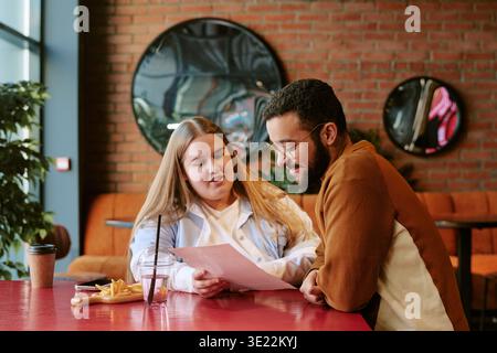 Jeune femme et jeune homme du moyen-Orient examinant des documents ensemble Banque D'Images