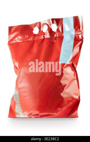 Un sac en plastique rouge rempli de matériau granulaire, qui est visible à travers une fenêtre transparente au fond, peut-être une toilette pour chat, est isolé Banque D'Images