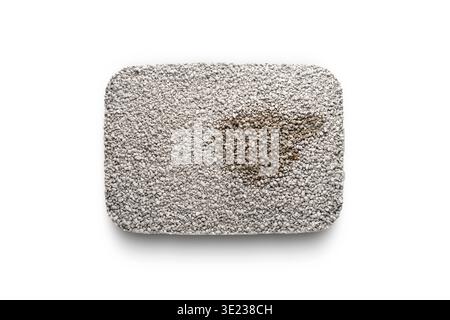 Plateau transparent avec mastic d'argile bentonite pour une litière de chat, vue de dessus sur un fond isolant blanc. Texture : fines granulés gris de naturel Banque D'Images