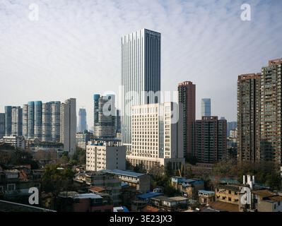 Perspective grand angle de l'évolution d'une ville, avec de denses maisons traditionnelles de faible hauteur au premier plan et un groupe d'imposants comm modernes Banque D'Images