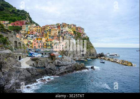 Vue panoramique sur le village de Manarola à Cinque Terre, Italie, avec des maisons colorées perchées sur des falaises au-dessus de la mer Méditerranée. Pittoresque côte Banque D'Images