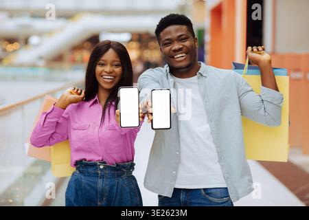 Heureux couple profitant du shopping ensemble dans un centre commercial avec des sacs dans les mains Banque D'Images
